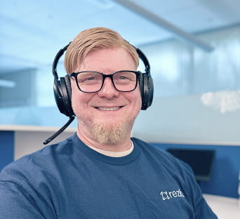 Rezku support team member with headset and Rezku shirt in the office