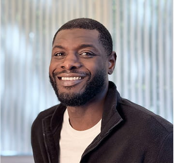Rezku team member smiling in a black jacket professional portrait